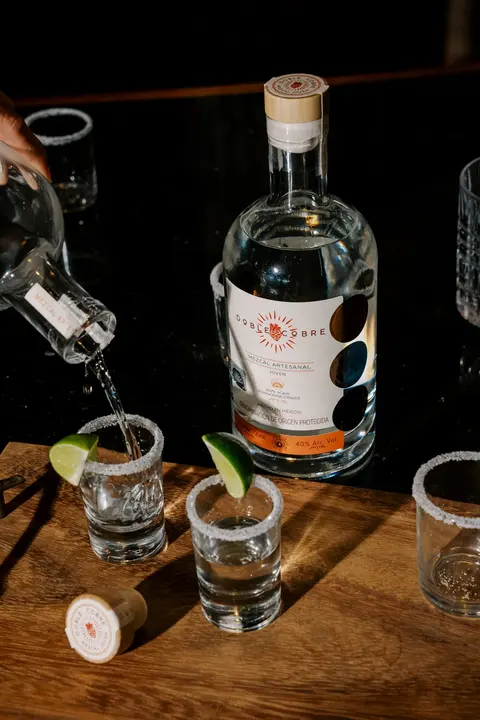 Mezcal Doble Cobre servido en caballitos escarchados con limón