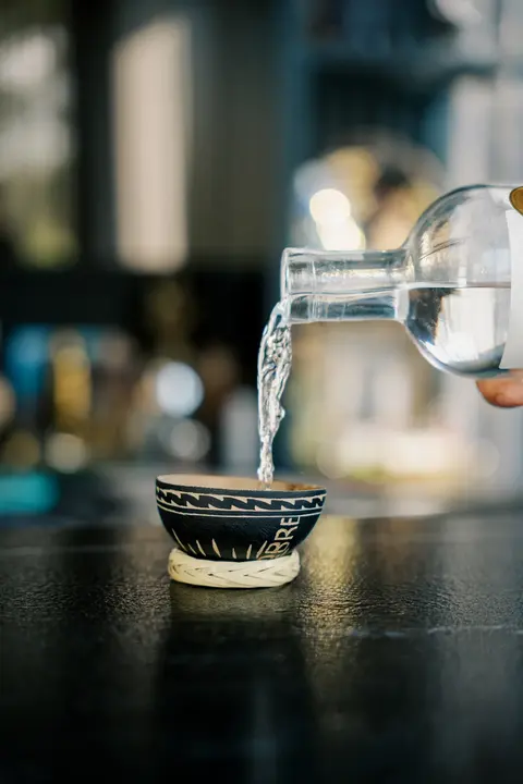 Mezcal Doble Cobre sirviéndose en una copa de barro tradicional