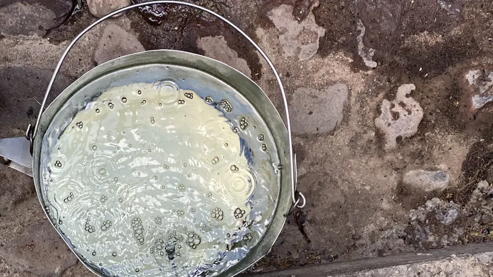 Mezcal recién destilado cayendo del alambique de cobre a una cubeta